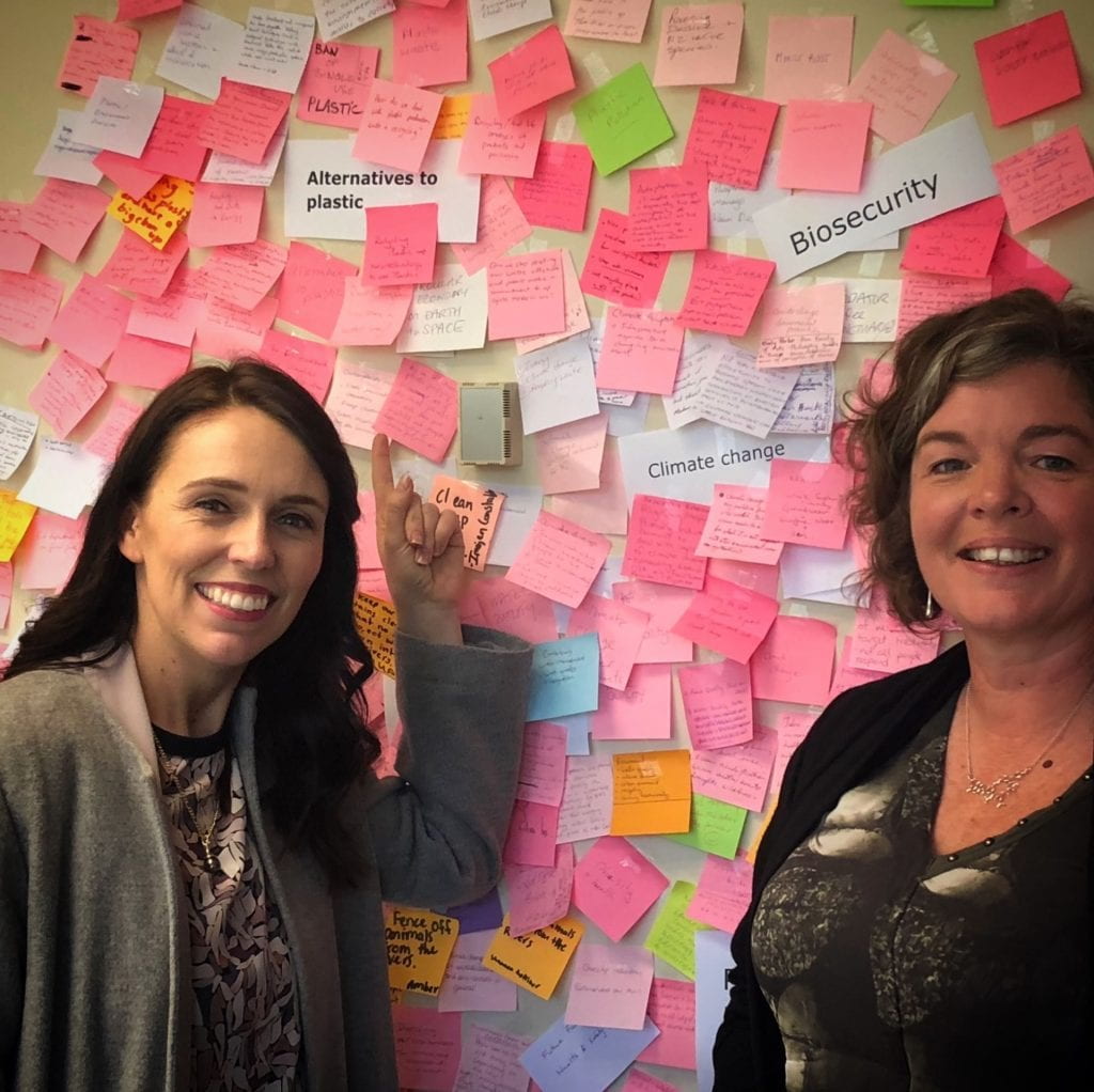 Juliet and the PM Jacinda Ardern in front of the OPMCSA "post-it wall" of ideas