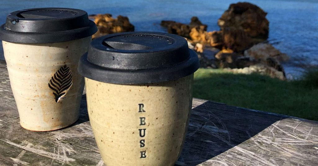 Reusable coffee cups made of ceramic with the word "reuse" written on one
