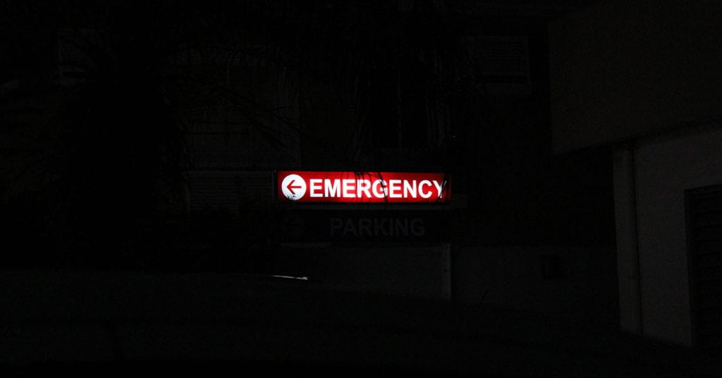 A red illuminated emergency sign in the darkness