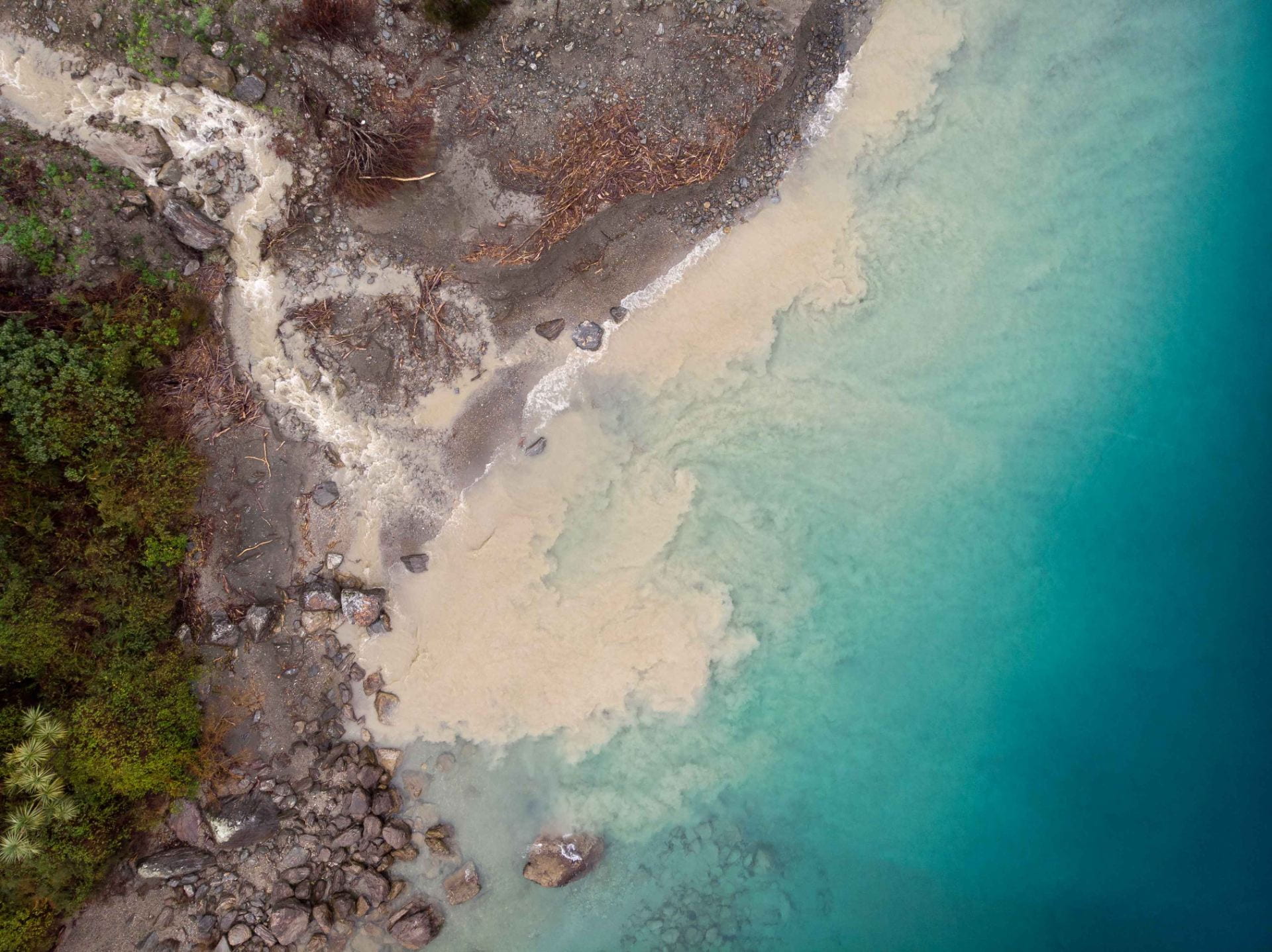 Aerial photo of sediment run-off from a stream into the ocean