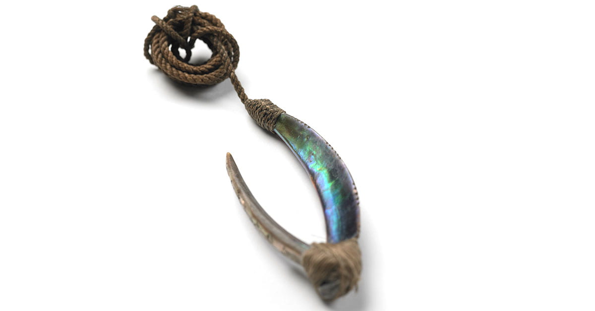 a pā kahawai or trolling lure fish hook made with iridescent blue pāua shell
