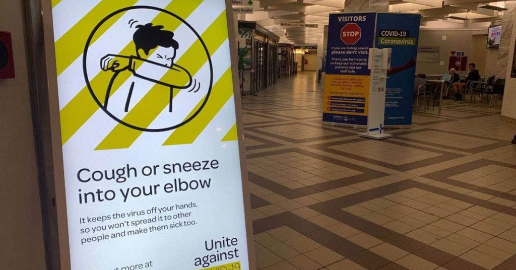 A poster encouraging people to sneeze into their elbow