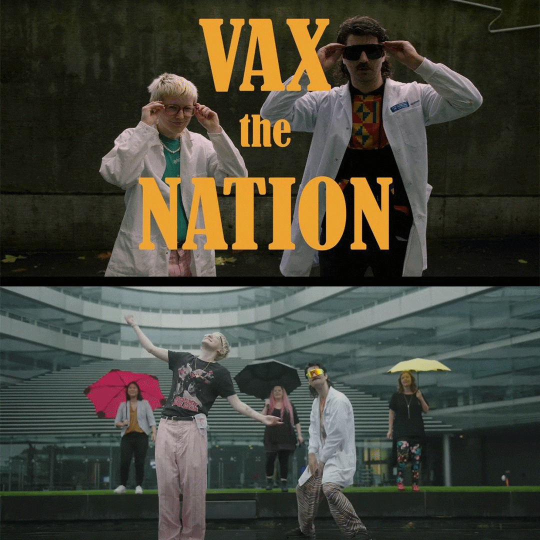 Two people in lab coats adjusting glasses behind words that read 'Vax the Nation'